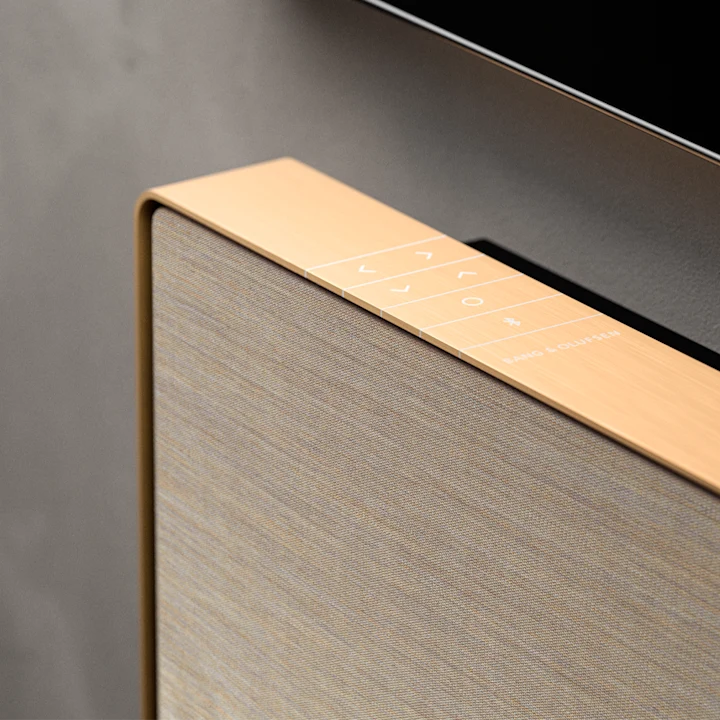 Bang & Olufsen Beosound Stage soundbar i træfinish med stofgrill og touch-betjening på toppen