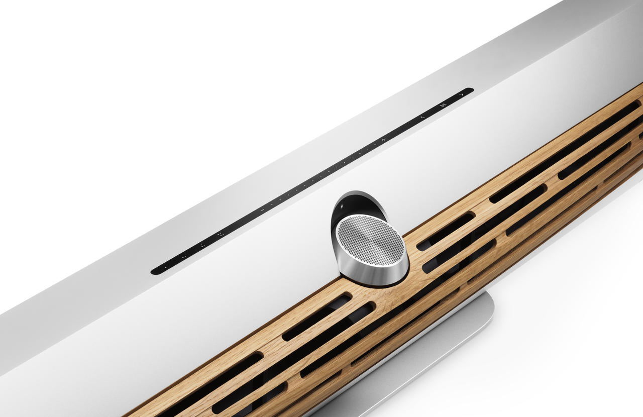 Beosound Premiere soundbar med hvid finish, træ-grill og sølv højttalerelement set fra oven
