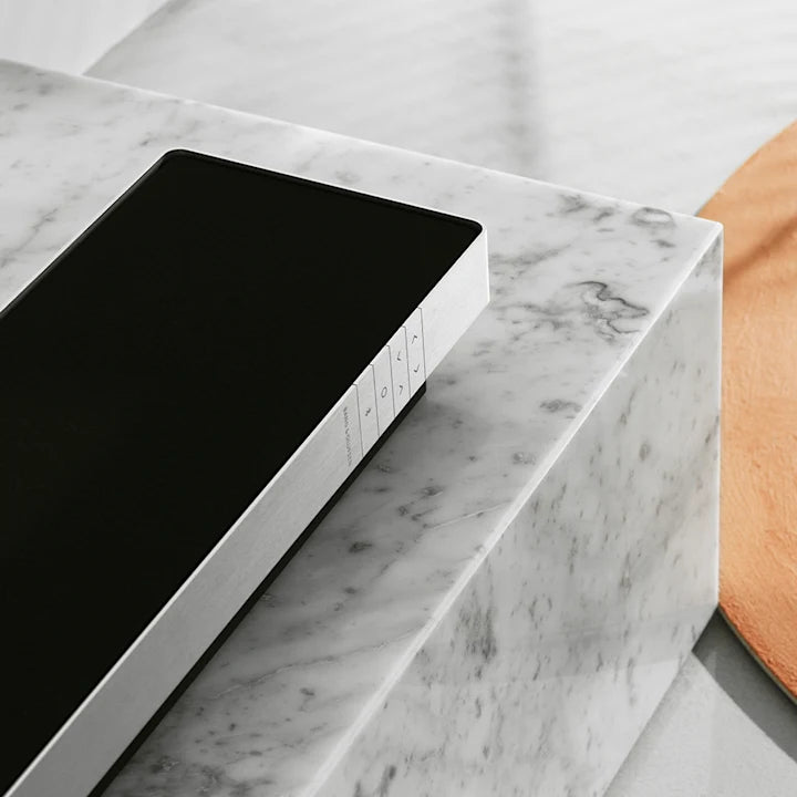 Bang & Olufsen Beosound Stage soundbar placeret på hvidt marmorbord